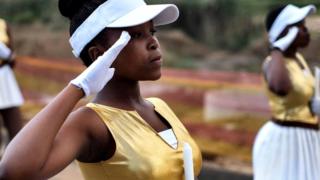South African majorettes salute as they parade near the house of Winnie Mandela Soweto, Johannesburg, on April 8, 2018.