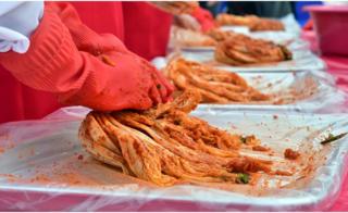 Participants take part in a kimchi making event during the Seoul Kimchi Festival outside the city hall in Seoul on 6 November 2015.