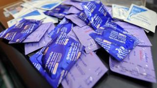 This picture taken on 27 June 2012 shows Thanakorn or Gigi packing condoms with leaflets before giving them to transgender people at The Poz Home Center in Bangkok