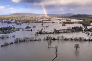 A rainbow appears over flooded fields in the Wye Valley, near the hamlet of Wellesley.