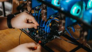 A crypto-currency mining machine being adjusted