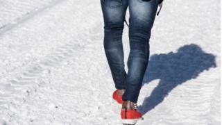 Un migrant de Côte d'Ivoire marche dans la neige avec des baskets et pas de chaussettes en route vers le Col de l'Echelle, un col enneigé pour franchir la frontière entre l'Italie et la France, le 13 janvier 2018 près de Bardonecchia , Alpes italiennes.