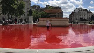 Campaigner in red Trafalgar Square fountain