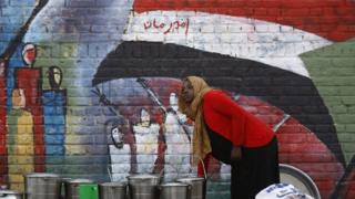 فتاة ترسم على أحد الجدران علم بلادها