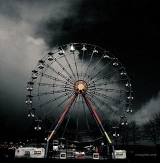 Ferris wheel under dark skies