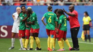 L'entraîneur du Cameroun, Alain Djeumfa, tente de calmer ses joueuses frustrées par l'arbitrage vidéo.