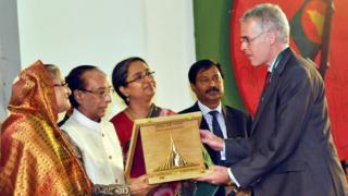 মৈত্রী ১৯৭১: বাংলাদেশে স্বাধীনতা যুদ্ধের সময় অবদানের জন্য বিবিসি ওয়ার্ল্ড সার্ভিসের পরিচালক পিটার হরকস্-এর হাতে 'বাংলাদেশ মুক্তিযুদ্ধ মৈত্রী সম্মাননা' তুলে দেন রাষ্ট্রপতি জিল্লুর রহমান এবং প্রধানমন্ত্রী শেখ হাসিনা। সাথে আছেন পররাষ্ট্রমন্ত্রী দীপু মনি, মার্চ, ২০১১ সাল. ঢাকা।