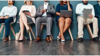 Pessoas sentadas em diferentes cadeiras trabalhando