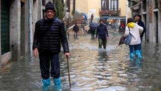 People walk the streets of Venice during exceptionally high water levels, 13 November 2019