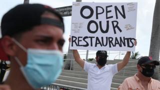 Alex Aguilar (C) along with restaurant owners, workers and supporters gather to protest new measures