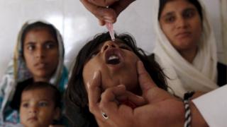 21 октября 2014 года девочка получает капли вакцины против полиомиелита в государственном диспансере в трущобах Карачи, Пакистан. Воинственные нападения на работников здравоохранения прекратились, но остаются серьезной угрозой