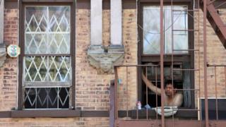 A man looks outside his window in New York