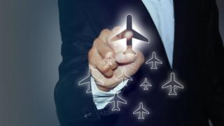 Una persona "haciendo clic" en un avión en una pantalla imaginaria