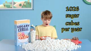 Мальчик в окружении кусочков сахара на завтрак и пакетик сладких сухих завтраков
