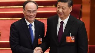 Ван Цишань (слева) пожимает руку президенту Си Цзиньпину, став его заместителем