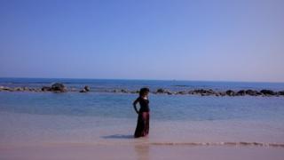 Woman in Sri Lanka on beach next to sea