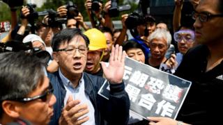 何君尧(中)参观香港警察机动部队行动基地后被泛民主派议员包围(12/8/2019)