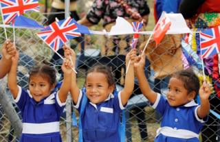 school children waving flags