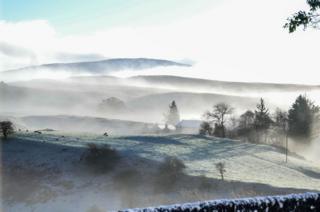 Misty and frosty sunrise over landscape