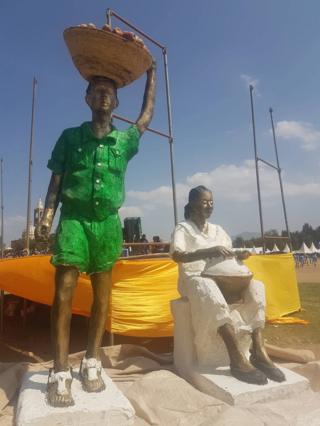 በለስ ብኻፈር ዝተሸከመ ቆልዓን ጥሕሎ እትሰርሕ ወይዘሮን ዘርኢ ቅርፂ፥ ኣብ ማእኸል ጎደና ዓድግራት።