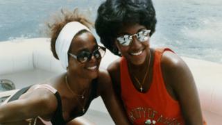 Whitney Houston (left) and Robyn Crawford relax on a yacht during a break on her 1987 Australian tour