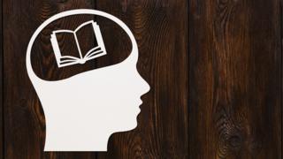 Dibujo de un figura humana con un libro en la cabeza.