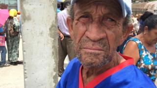 Aposentado e outras pessoas em fila para sacar dinheiro na Venezuela