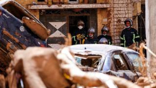 Members of the rescue team from the Egyptian army look at the damaged cars, following a powerful storm and heavy rainfall hitting the country, in Derna, Libya