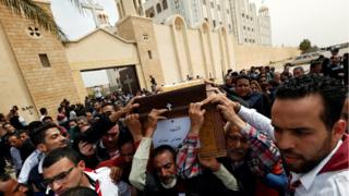 Relatives react as they mourn for the victims of the Palm Sunday bombings during their funeral at the Monastery of Saint Mina "Deir Mar Mina" in Alexandria