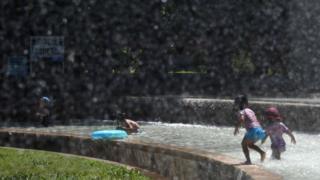 Children play in a water fountain in a Tokyo park, as a heatwave grips Japan, 10 July 2018