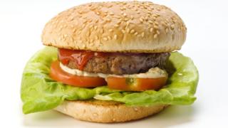 Hamburger. Beef pattie in a bun with salad, relish and ketchup