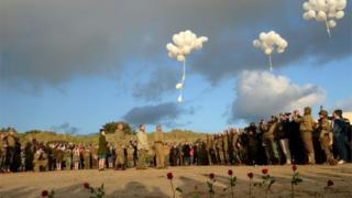 French WWII enthusiasts plant red roses and release white balloons in tribute on Utah beach