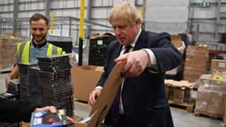 Boris Johnson packs boxes at factory in the west midlands.