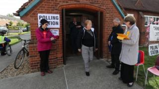 A voter leaves Trumpington village hall in Cambridgeshire