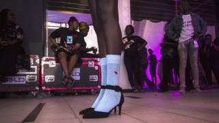 A model in socks and high heels backstage during Dakar Fashion Week in Dakar, Senegal