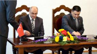 Turgay Şen (solda) 2012 yılında Moldova Savunma Bakanı Vitalie Marinuta ile özel bir işbirliği anlaşması izmalarken