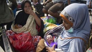 A woman (R) holds her new grandchild who was just born outside Undata hospital in Palu in Central Sulawesi on October 2, 2018, four days after a strong earthquake and tsunami hit the area