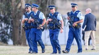 Des agents de police surveillent le cimetière de Christchurch où sont enterrées les premières victimes de la tuerie.