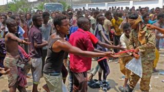 በየመን ኤደን ከተማ በስታዲየም ውስጥ የሚገኙ ስደተኞች እርዳታ ለመቀበል ሲጋፉ