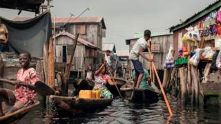 People navigate the the waterways of Makoko waterfront community in Lagos on May 15, 2018. Members of various waterfront communities and the Nigerian Slum/Informal Settlement Federation have protested on the day marking one year anniversary of the forced eviction of the Otodo Gbame community, a Lagos shanty town,
