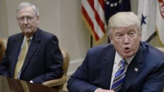 Donald Trump talks while Mitch McConnell looks on.