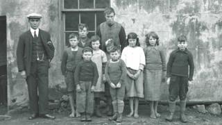 Raonaid NicIain (sa mheadhan le a h-aodann falaichte).