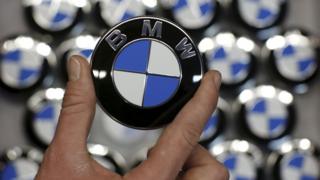 Hand holding round BMW logo