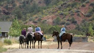 Muejres mormonas sobre caballos en Colorado City, Arizona.