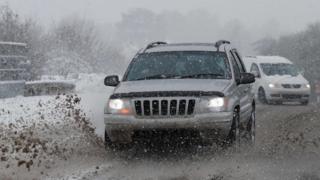 Cars are driven through snow and slush near Chievely, Berkshire.