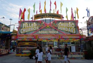 A churros stand brightly decorated with lights and flags