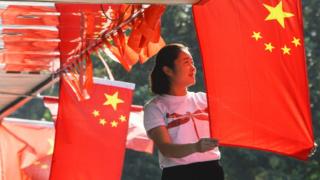 A woman hangs Chinese flags in Beijing