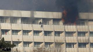 A man tries to escape from a balcony at Kabul's Intercontinental Hotel during an attack by gunmen in Kabul, 21 January