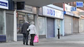 People walking past closed shops