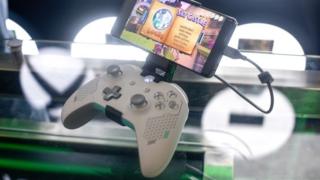 An Xbox controller is seen with a phone clipped to its top
